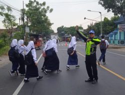 Situasi Ramai Pantura, Anggota Polsek Kragan Atur Lalin & Sebrangkan Anak Sekolah