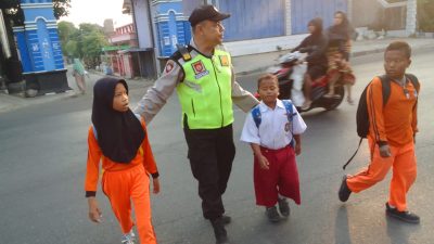 Semangat Pagi, Anggota Polsek Kragan Bantu Sebrangkan Anak-anak Sekolah