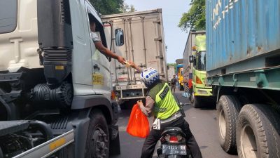 Kemacetan Belum Kunjung Terurai, Dengan Gunakan Sepeda Motor Satlantas Polres Rembang Kembali Bagi-bagi Makanan